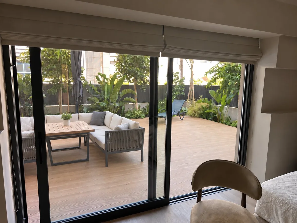 A suite with a large sliding opening in dark aluminium onto the terrace